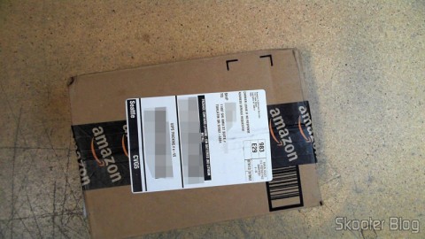 Pacote da Amazon coma a Câmera Digital Canon PowerShot ELPH 330 HS 12.1 MP Wi-Fi CMOS Zoom Óptico 10X Lentes 24mm Video Full HD 1080p com cartão de memória 32GB, bolsa e bateria extra, em foto tirada pela Shipito
