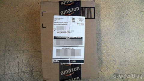Pacote da Amazon coma a Câmera Digital Canon PowerShot ELPH 330 HS 12.1 MP Wi-Fi CMOS Zoom Óptico 10X Lentes 24mm Video Full HD 1080p com cartão de memória 32GB, bolsa e bateria extra, em foto tirada pela Shipito
