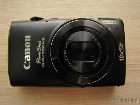 Amazon via Shipito: Câmera Digital Canon PowerShot ELPH 330 HS 12.1 MP Wi-Fi CMOS Zoom Óptico 10X Lentes 24mm Video Full HD 1080p (Canon PowerShot ELPH 330 HS 12.1 MP Wi-Fi Enabled CMOS Digital Camera with 10x Optical Zoom 24mm Wide-Angle Lens and 1080p Full HD Video (Black)) 21 Parte Frontal da Câmera Digital Canon PowerShot ELPH 330 HS 12.1 MP Wi-Fi CMOS Zoom Óptico 10X Lentes 24mm Video Full HD 1080p (Canon PowerShot ELPH 330 HS 12.1 MP Wi-Fi Enabled CMOS Digital Camera with 10x Optical Zoom 24mm Wide-Angle Lens and 1080p Full HD Video (Black))