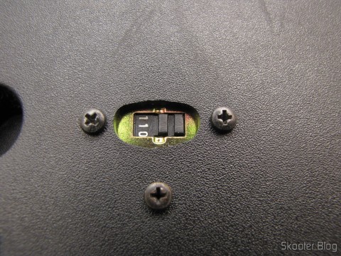 Chave seletora 110V/220V na parte de baixo do console