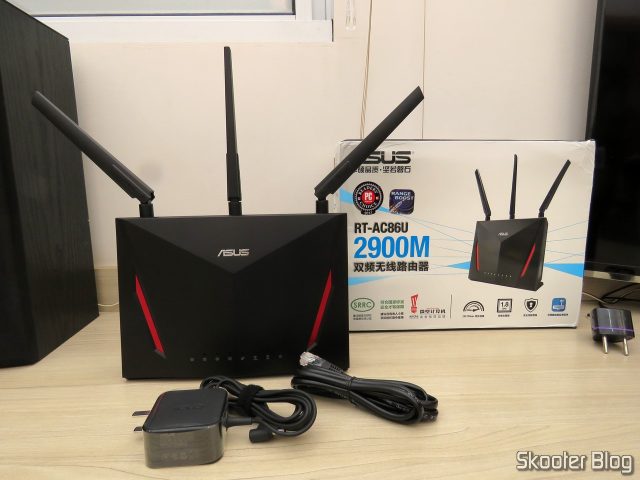 Roteador ASUS RT-AC86U, fonte de alimentação e cabo Ethernet.
