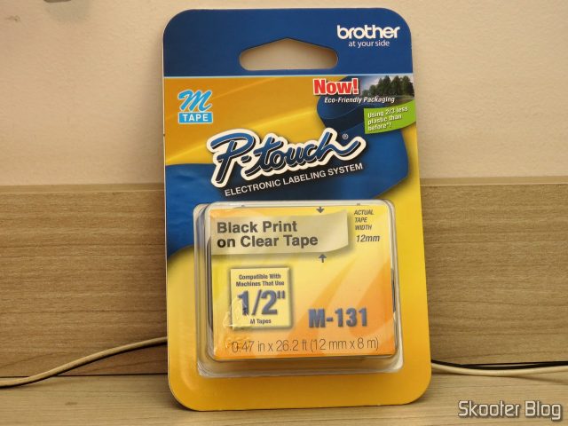 Fita p/ Rotulador M131 12mm Preto sobre Transparente Brother (Ref. M131), em sua embalagem.