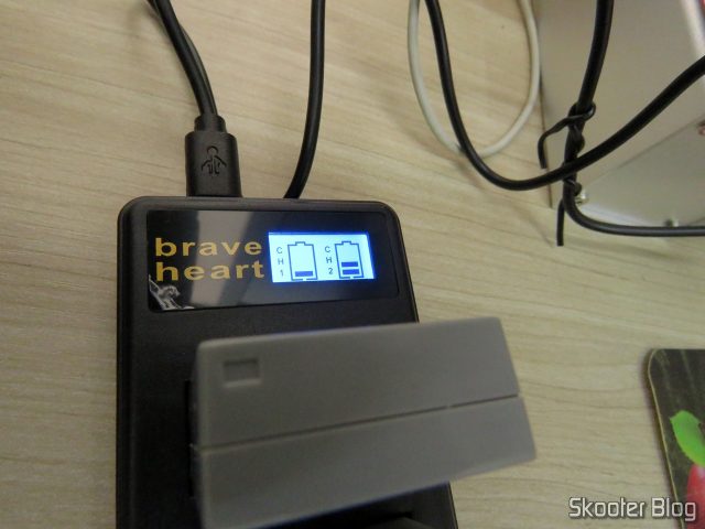 2 Baterias NB-10L para câmera Canon no Carregador USB com LCD, em funcionamento.
