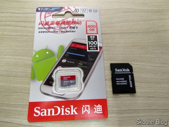 Cartão microSDXC Sandisk Ultra 400GB, em sua embalagem, e adaptador de microSD para SD.