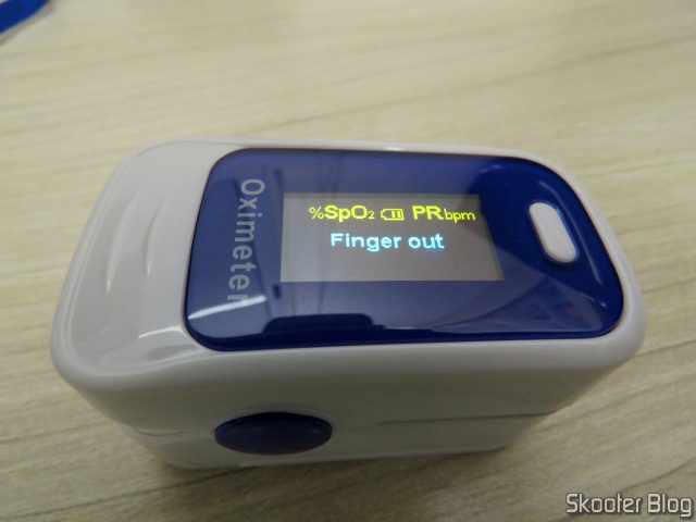 Oxímetro de Dedo OLED em Inglês e Português, em funcionamento.