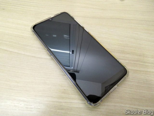 Capa para Xiaomi Mi 9 de TPU Macio TCiCPC, já instalada, chegando um pouco acima do limite da tela.