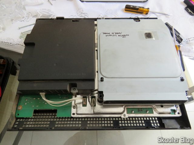 Meu PlayStation 3 com o chip HDMI defeituoso, trocado pelo técnico, colado sobre o drive de blu-ray, com nome do técnico e data do serviço.
