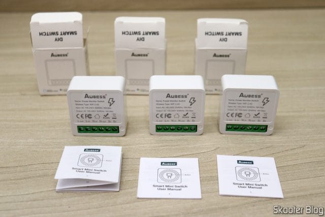 Três Mini Smart Switch Aubess, com suas embalagens e manuais.