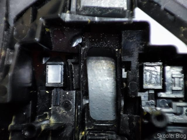 As plaquinhas que reduzem o atrito entre o botão do mouse e o botão do switch. A do lado esquerdo em bom estado e a do lado direito removida.