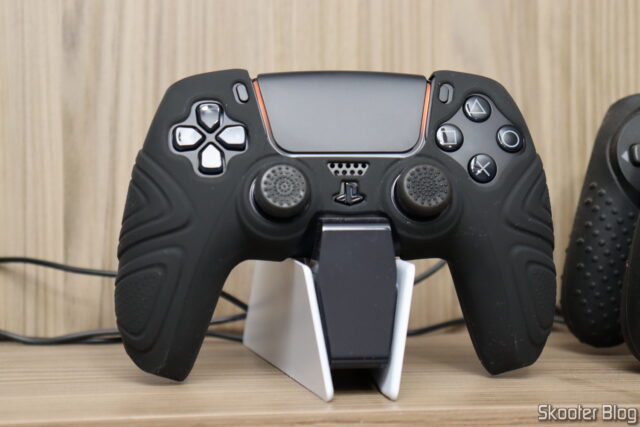 Controle Sony DualSense Midnight Black - PS5, com a capa de silicone e no DualSense Charging Station.